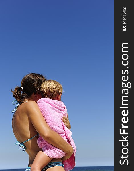 Summer vacation on the beach: mother carrying her daughter. Summer vacation on the beach: mother carrying her daughter