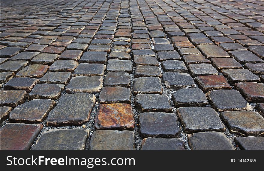 Close shot of cobblestone road with big uequal stones. Close shot of cobblestone road with big uequal stones