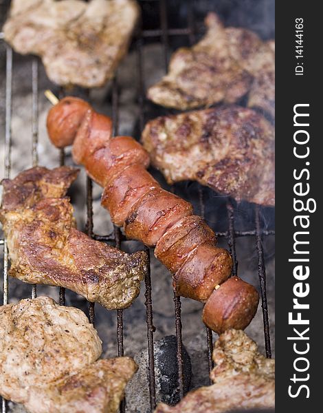 Closeup on grilled sliced sausage and beef on a grill. Closeup on grilled sliced sausage and beef on a grill