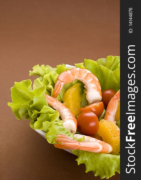 Shrimps, tomato and lettuce on brown background. Shrimps, tomato and lettuce on brown background