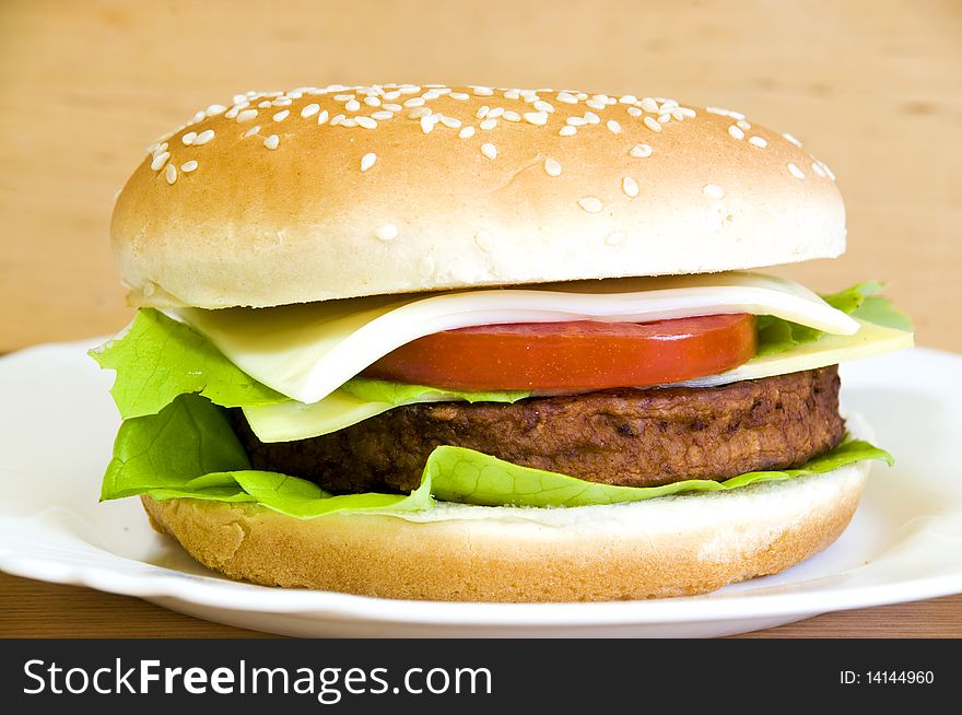 Cheeseburger with beef, lettuce, cheese, onion and tomato. Cheeseburger with beef, lettuce, cheese, onion and tomato