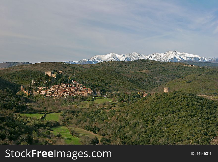 Medieval village with watch tower and dungeon at the feet of the pyrenees mountains covered with snow in france. Medieval village with watch tower and dungeon at the feet of the pyrenees mountains covered with snow in france