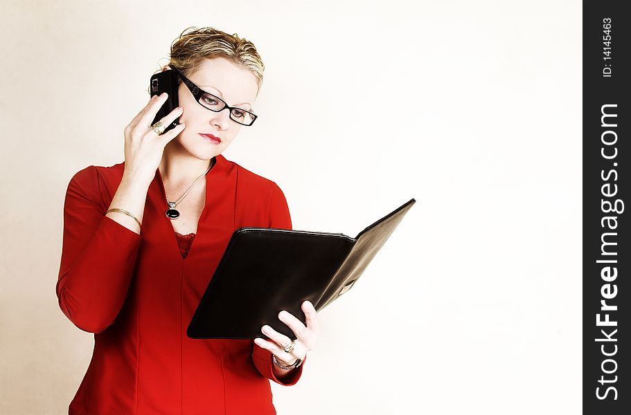 Business woman on phone while looking in folder