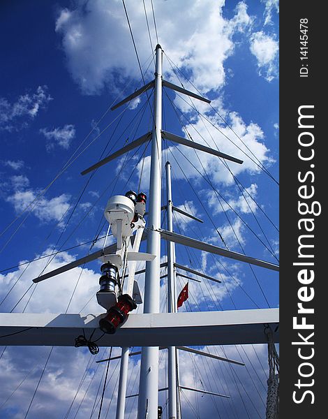 Mast of the walking sea yacht on blue cloudy sky background