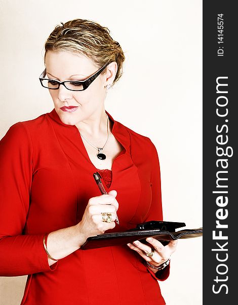 Business woman in red suit holding an open folder and pen