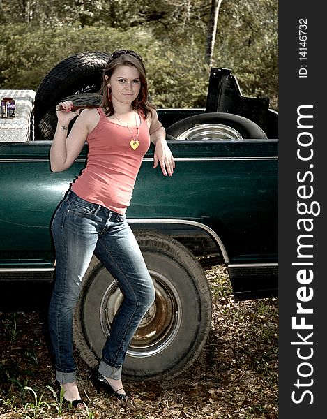 Young pretty woman in high heels standing next to a truck with tires in the back and a tool box holding a tire tool. Young pretty woman in high heels standing next to a truck with tires in the back and a tool box holding a tire tool