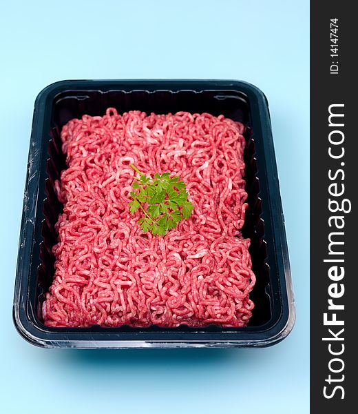 Fresh minced beef isolated against a blue background. Fresh minced beef isolated against a blue background