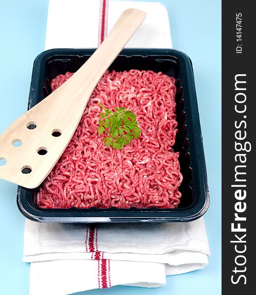 Fresh minced beef isolated against a blue background. Fresh minced beef isolated against a blue background