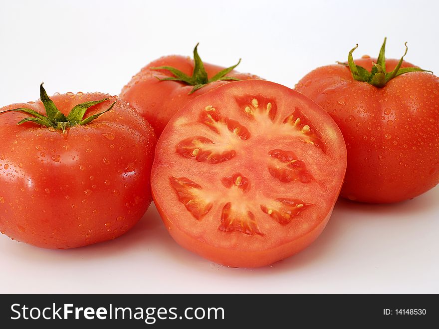 Red sprinkled tomatoes with water on the white background. Red sprinkled tomatoes with water on the white background