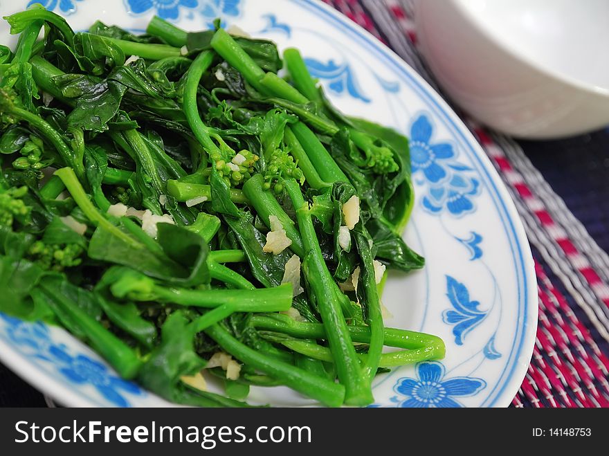 Closeup of green leafy vegetables stir fried and cooked oriental style. For concepts such as food and beverage, diet and nutrition, and healthy eating. Closeup of green leafy vegetables stir fried and cooked oriental style. For concepts such as food and beverage, diet and nutrition, and healthy eating.