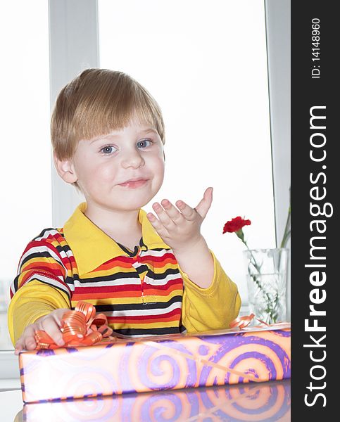 Portrait of the little boy with a gift box on a background. Portrait of the little boy with a gift box on a background