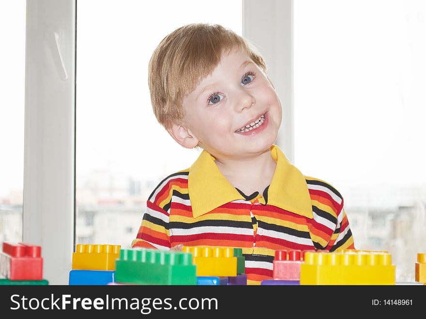 The beautiful little boy poses on a light background. The beautiful little boy poses on a light background