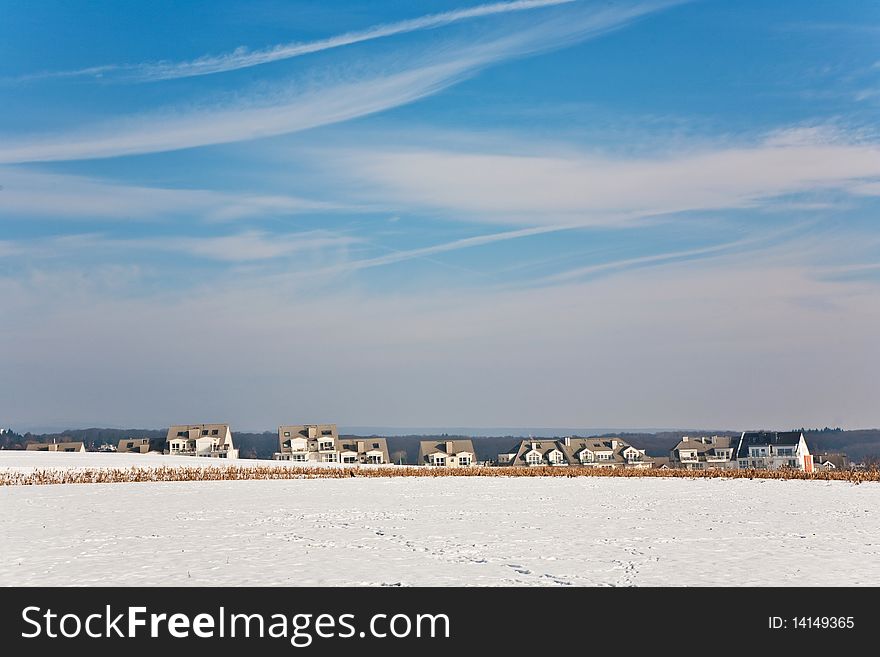 Landscape with  housing area in snow and blue sky