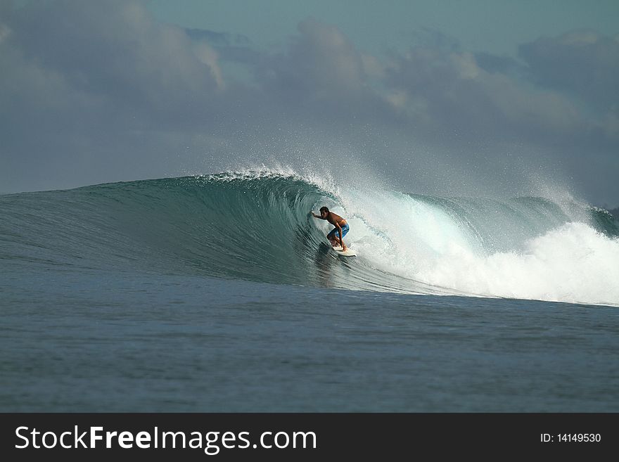 Surfer riding the barrel of tropical wave, Indonesia. Surfer riding the barrel of tropical wave, Indonesia
