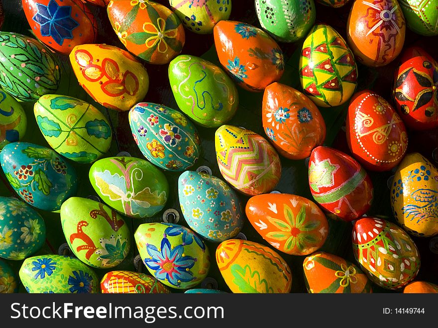 Many colored eggs with drawings on the surface for background