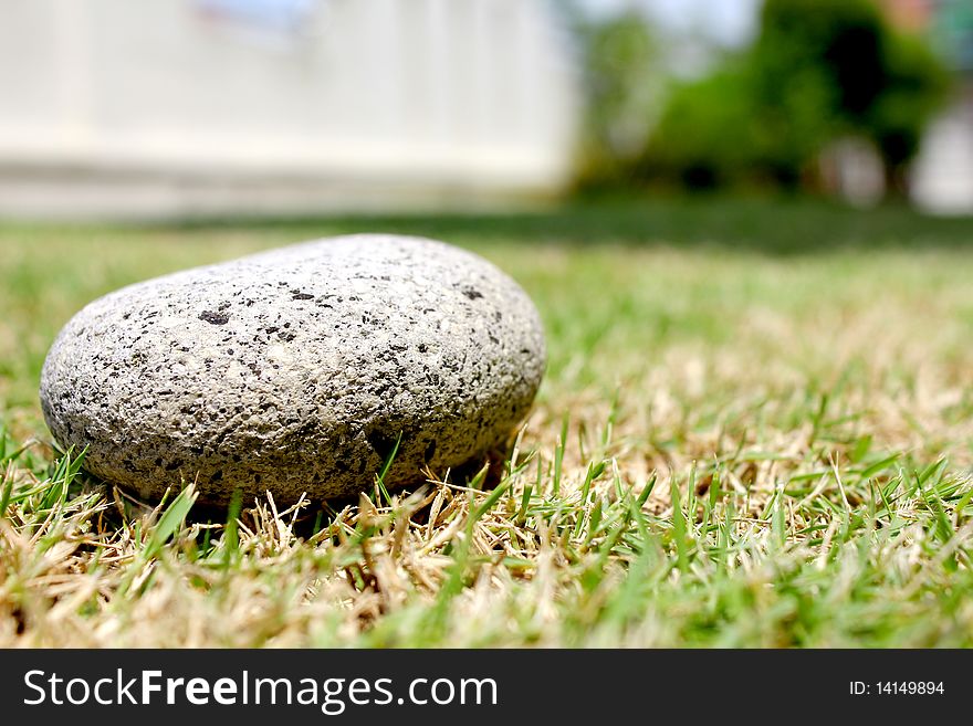 A single round stone on the grass