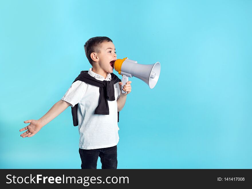 Cute funny boy with megaphone on color background.