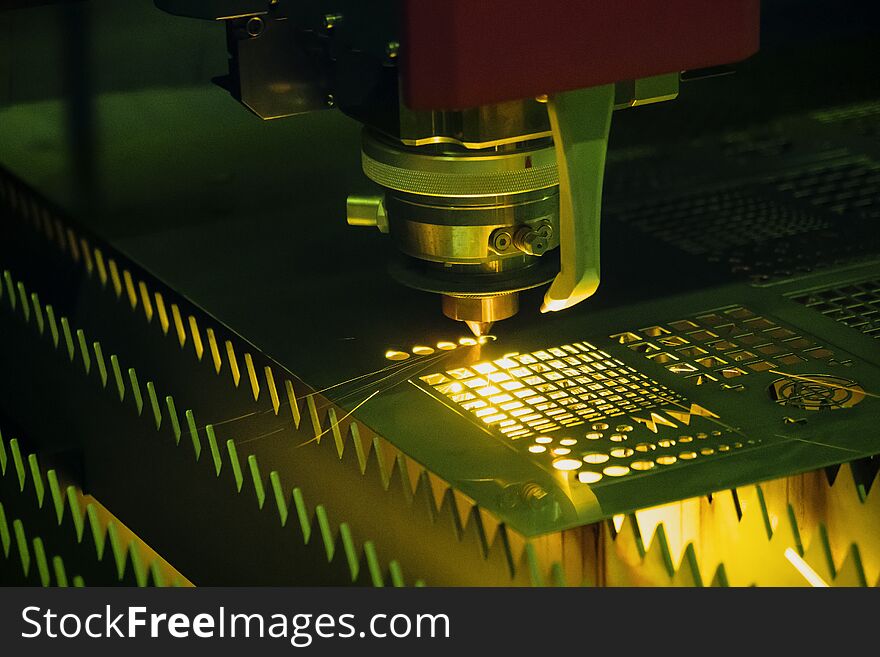 The CNC fiber laser cutting machine cutting the metal plate with the sparking light. The sheet metal working operation. The CNC fiber laser cutting machine cutting the metal plate with the sparking light. The sheet metal working operation