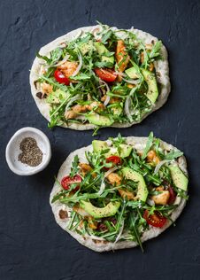 Pan-fried Flatbread Chicken, Avocado, Tomatoes, Arugula Pizza On Dark Background Royalty Free Stock Images