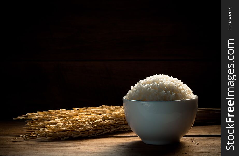 Steam White rice in white ceramic bowl on wood table for healthy meal. Cook concept. Selective focus