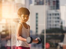 Boy Is Working Out With Dumbbell By The Windows City Royalty Free Stock Images