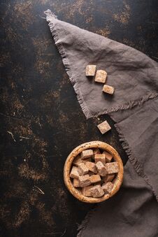 Brown Sugar Cubes In A Bowl On A Dark Background. Top View, Space For Your Text Royalty Free Stock Photography
