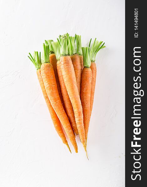 Bunch of fresh carrots with green leaves on white wooden background. Vegetables and market concept. Soft focus with Copy space, top view food nature leaf healthy natural orange organic vegetarian agriculture farm freshness nutrition raw vitamin harvest ingredient nutritional agricultural product ripe local season garden colorful vegan wholesale nobody eating young fiber clean trade snack diet farmers. Bunch of fresh carrots with green leaves on white wooden background. Vegetables and market concept. Soft focus with Copy space, top view food nature leaf healthy natural orange organic vegetarian agriculture farm freshness nutrition raw vitamin harvest ingredient nutritional agricultural product ripe local season garden colorful vegan wholesale nobody eating young fiber clean trade snack diet farmers
