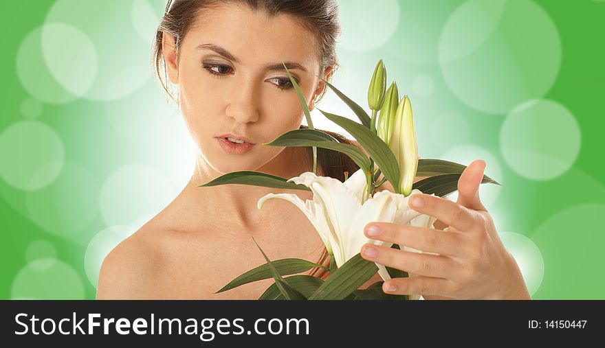 Portrait of a young and attractive brunette holding a flower. Image taken on a green abstract background. Portrait of a young and attractive brunette holding a flower. Image taken on a green abstract background.