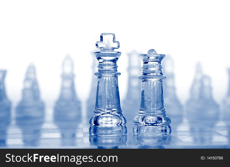 Glass chess pieces with blue light, isolated