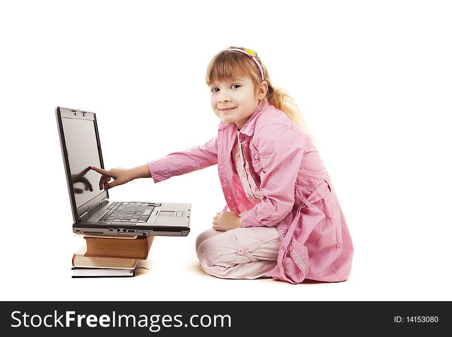 A little girl sitting at a laptop on a white background. A little girl sitting at a laptop on a white background