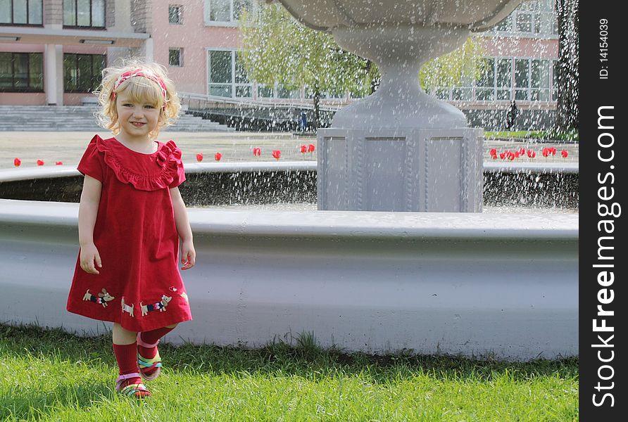 Blond girl on the walk near the fountain