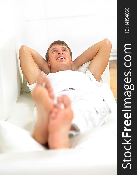 Closeup portrait of a young man resting on sofa at home