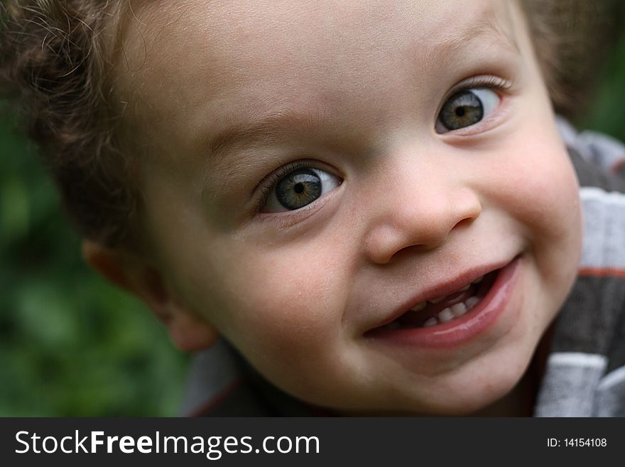 Cute young boy smiling, in an outdoor setting. Cute young boy smiling, in an outdoor setting.