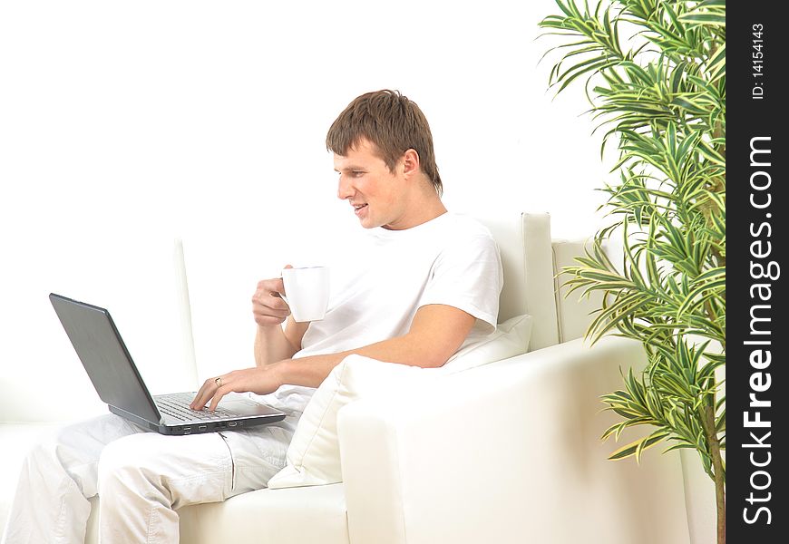 Miling young man working on laptop computer at home