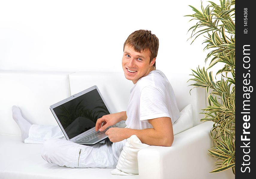 Portrait of a young man looking away while working on laptop