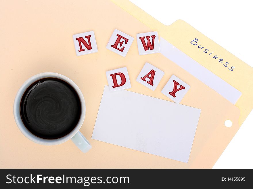 Folder with office documents, a cup of hot coffee and inscription New Day. Folder with office documents, a cup of hot coffee and inscription New Day.