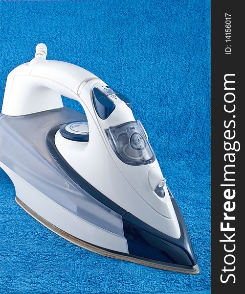 Electric iron on blue towel