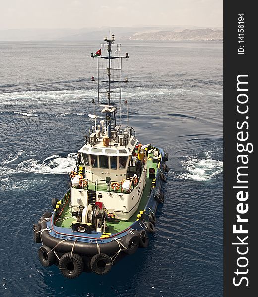 Tug boat working sailing vessel on sea