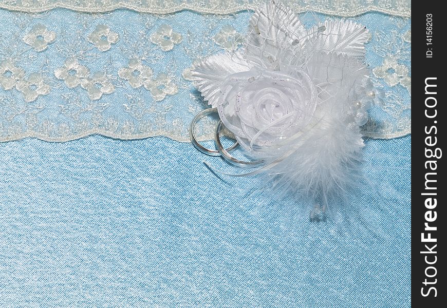 Background from blue silk with weddings rings and lace