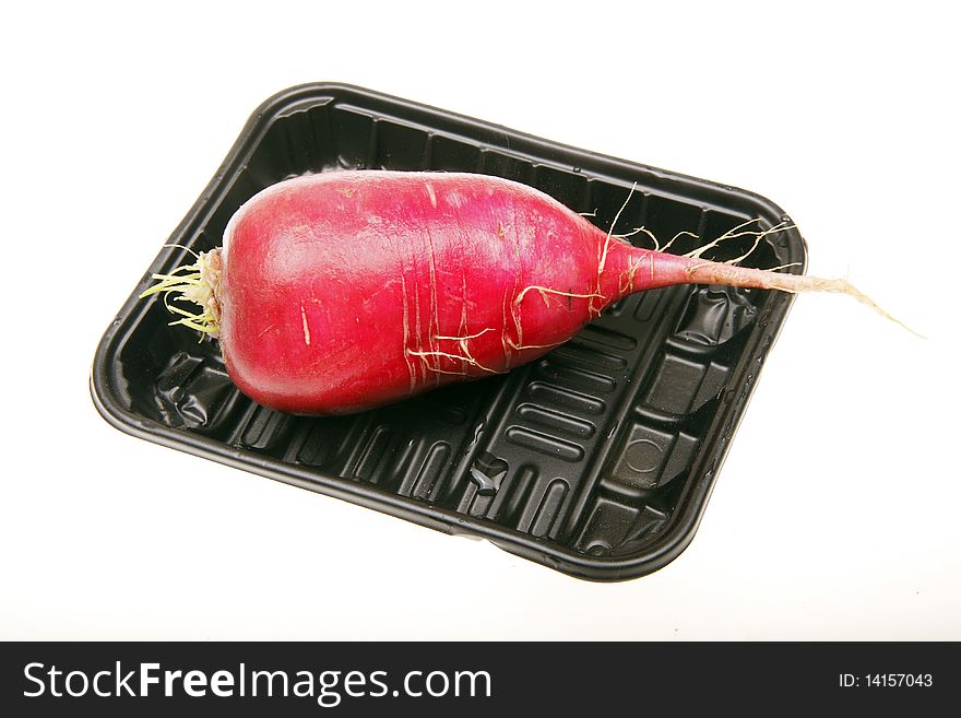 Fresh red radish in a dark plastic box. (on white)