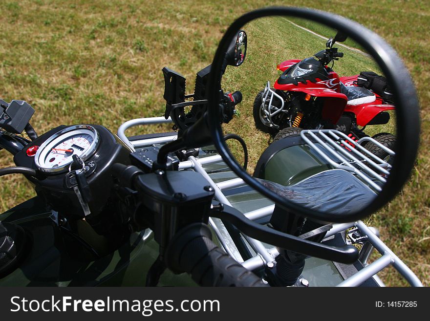 Red quad bike in rear view mirror