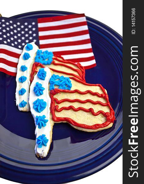 American flag and flag sugar cookies on a navy blue plate and isolated background. American flag and flag sugar cookies on a navy blue plate and isolated background.