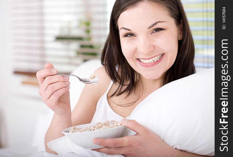 Young happy brunette woman with corn flakes