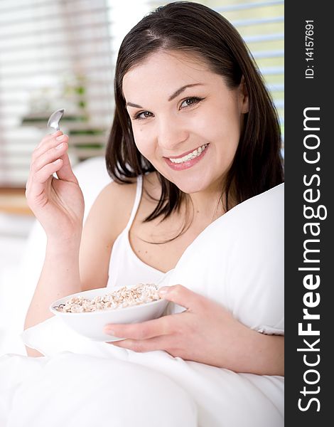 Young happy brunette woman with corn flakes