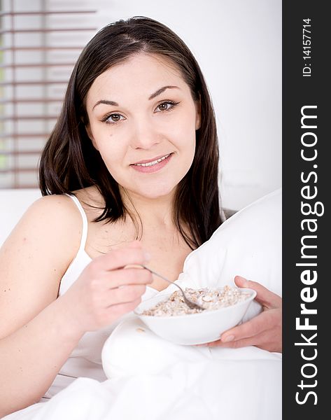 Young happy brunette woman with corn flakes