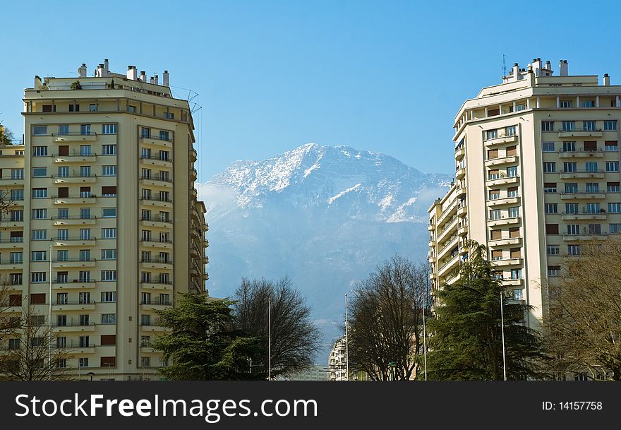 View of a mountain between two city buildings. View of a mountain between two city buildings.