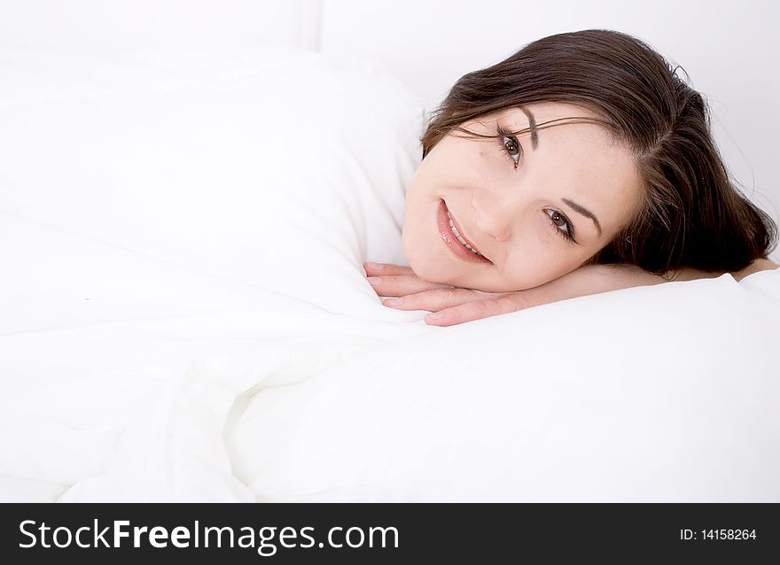 Young attractive brunette woman lying in bed. Young attractive brunette woman lying in bed
