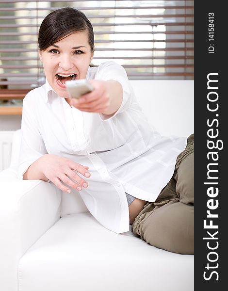 Young happy woman sitting on sofa with remote control. Young happy woman sitting on sofa with remote control