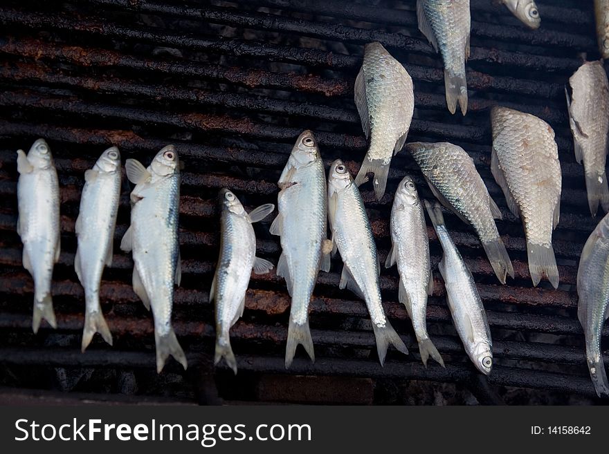 Image of fish being grilled over charcoal. Image of fish being grilled over charcoal.