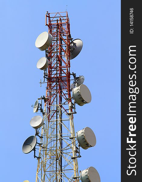 A telecommunications tower with a clear blue sky